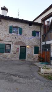 een stenen gebouw met groene deuren en een kerstboom buiten bij La corte dei celti la fonte 1 in San Benedetto Del Querceto