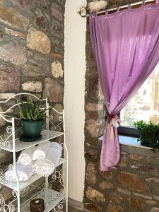 - une fenêtre avec un rideau violet et une étagère avec des serviettes dans l'établissement Masal Küçükköy Boutiquehotel, à Ayvalık