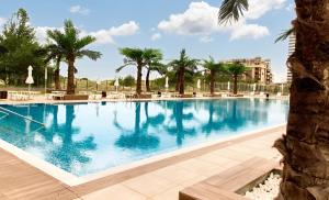 a large swimming pool with palm trees in a resort at Europe Hotel & Casino All Inclusive in Sunny Beach