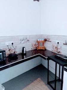 a kitchen with a counter and a table in it at Area 51 Apartment in Mirissa