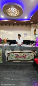 a man standing behind a counter in a restaurant at Hotel JM International (A Unit of Hotel Care Plaza) in Puri