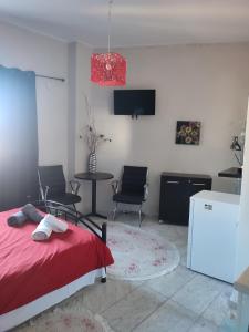 a bedroom with a bed and a table and a tv at Ονειροπαγίδα in Veria