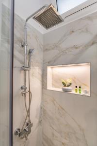 a shower in a bathroom with marble walls at Liros House in Nafpaktos