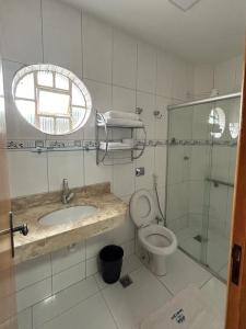 uma casa de banho com um lavatório, um WC e um chuveiro em Hotel Santa Clara em Caldas Novas