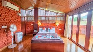 a bedroom with a bed in a red brick wall at Nature full Resort in Masinagudi