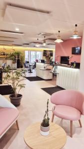 a living room with pink furniture and plants at Sure Hotel by Best Western Biarritz Aeroport in Biarritz