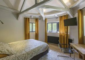 1 dormitorio con 1 cama, escritorio y ventanas en Lodge de Loire - rive gauche - proche Chambord, en Saint Laurent Nouan
