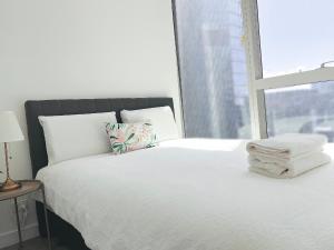 a bedroom with a bed with white sheets and a window at Wsp Lux 3b2b flat in CBD with balcony in Melbourne +12 photos