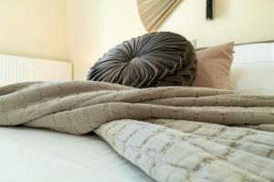 a pile of blankets sitting on top of a bed at Sweet Luxury House in Alepou