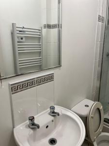 a bathroom with a sink and a toilet and a mirror at Nice House Near QMC in Nottingham