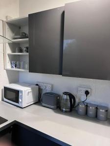 a kitchen counter with a microwave and appliances on it at Nice House Near QMC in Nottingham