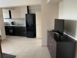 a kitchen with a black refrigerator and a sink at ЛАЗАРОВИ in Hisarya