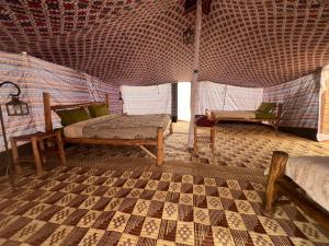 a room with a bed and chairs in a tent at Camp Rêve de Nomade in Lompoul