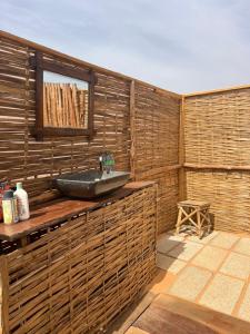 a bathroom with a sink on a wooden wall at Camp Rêve de Nomade in Lompoul