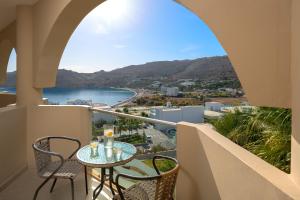 a balcony with a table and chairs and a view of the ocean at Lindos Royal Resort in Lindos