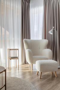 a living room with a chair and a table at Dream Garden Apartment - Free Parking - Welness Jacuzzi SPA in Sinaia