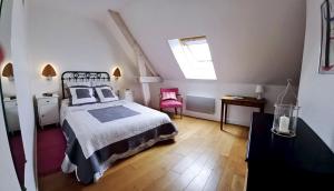 Un dormitorio con una cama grande y una ventana en Le Jardin des Lys en La Roche-Posay