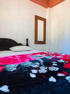 a bed with a colorful blanket on top of it at Micro wood cabana in Nuwara Eliya