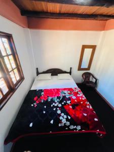 a bedroom with a bed covered in red flowers at Micro wood cabana in Nuwara Eliya