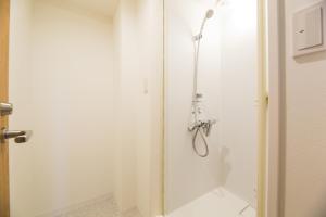 eine Dusche mit Glastür im Bad in der Unterkunft あやきちゲストハウス in Daikōchō