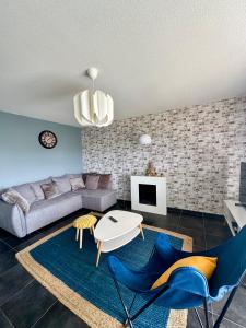 Spacieux T3 Standing Parking privé centre ville Montpellier في مونبلييه: غرفة معيشة مع أريكة وطاولة وكراسي