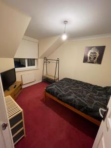 a bedroom with a bed and a flat screen tv at Room 4 - Chassagne Guest House in Church Coppenhall
