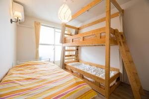 1 dormitorio con litera y escalera en あやきちゲストハウス, en Daikōchō