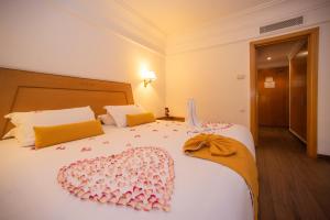 Hotel Timoulay and Spa Agadir في أغادير: غرفة نوم بسريرين عليها ديكورات وردية