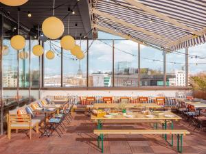 un ristorante con tavoli, sedie e ampie finestre di Eklo Paris Expo Porte de Versailles a Vanves