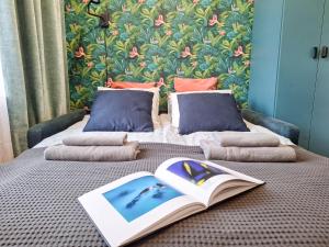Una cama con un libro abierto y almohadas. en Cracow city heart - 19th-century tenement house of Stanislaw Wyspianski, en Cracovia