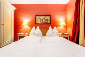 two white beds in a room with orange walls at Haus Raanwai Whg 3a in Rantum