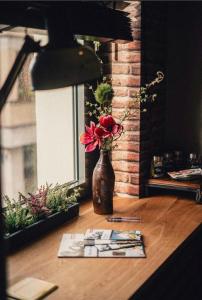 a vase with red flowers in it on a table at 36 Phô Cô Hotel & Suites in Weimar