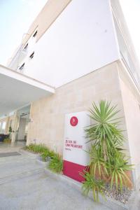 un panneau sur le côté d'un bâtiment avec des plantes dans l'établissement JS Sol de Can Picafort - Adults Only, à Can Picafort