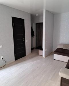 an empty room with two beds and a black door at Студия 2 комнаты в центре города in Kryvyi Rih