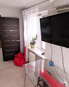 a living room with a glass table and a flat screen tv at Студия 2 комнаты в центре города in Kryvyi Rih