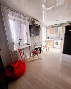 a living room with a table and a kitchen at Студия 2 комнаты в центре города in Kryvyi Rih