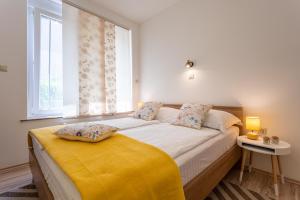 1 dormitorio con 1 cama grande con manta amarilla en Apartment Marangunija, en Malinska