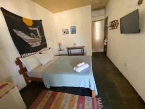 ein Schlafzimmer mit einem Bett und einem TV in einem Zimmer in der Unterkunft Pousada Marinheiro in Sítio