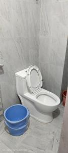 a bathroom with a toilet and a blue bowl at Hotel JM International (A Unit of Hotel Care Plaza) in Puri