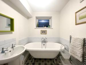 a white bathroom with a tub and a sink at Central Cheltenham House - By Suitely in Cheltenham