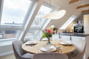 uma sala de jantar com mesa, cadeiras e janelas em Strandbude Sylt em Westerland