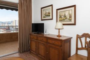 een kamer met een bureau, een tv en een lamp bij Florazar 2, Viii-8-B in Cullera