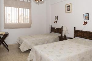 a bedroom with two beds and a window at Lider, 4-D in Cullera +17 photos