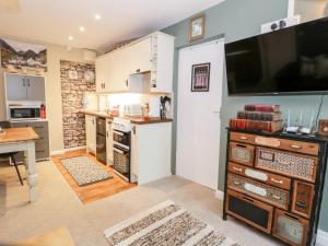 een keuken met een grote tv aan de muur bij Cwm Caeth Cottage in Caernarfon