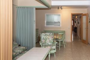 een woonkamer met een bank en een tafel en stoelen bij Amador, 3º-J in Cullera