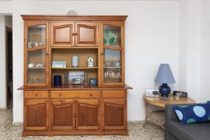 a wooden cabinet in a living room with a table at Hawai Bajo in Faro de Cullera