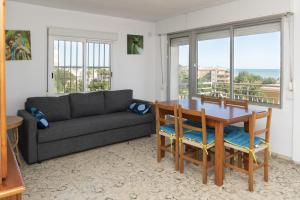 a living room with a couch and a table and chairs at Hawai Bajo in Faro de Cullera