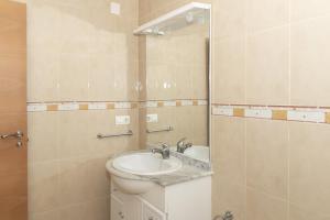 a bathroom with a sink and a mirror at Hawai Bajo in Faro de Cullera +12 photos