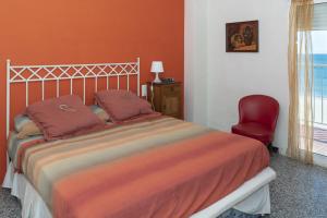una camera da letto con un letto e una sedia rossa di Montemar, C-8º-22 a Cullera