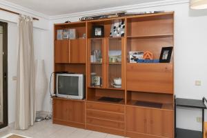 un centro de entretenimiento de madera con TV en una habitación en Dosel, 6º-30, en Cullera